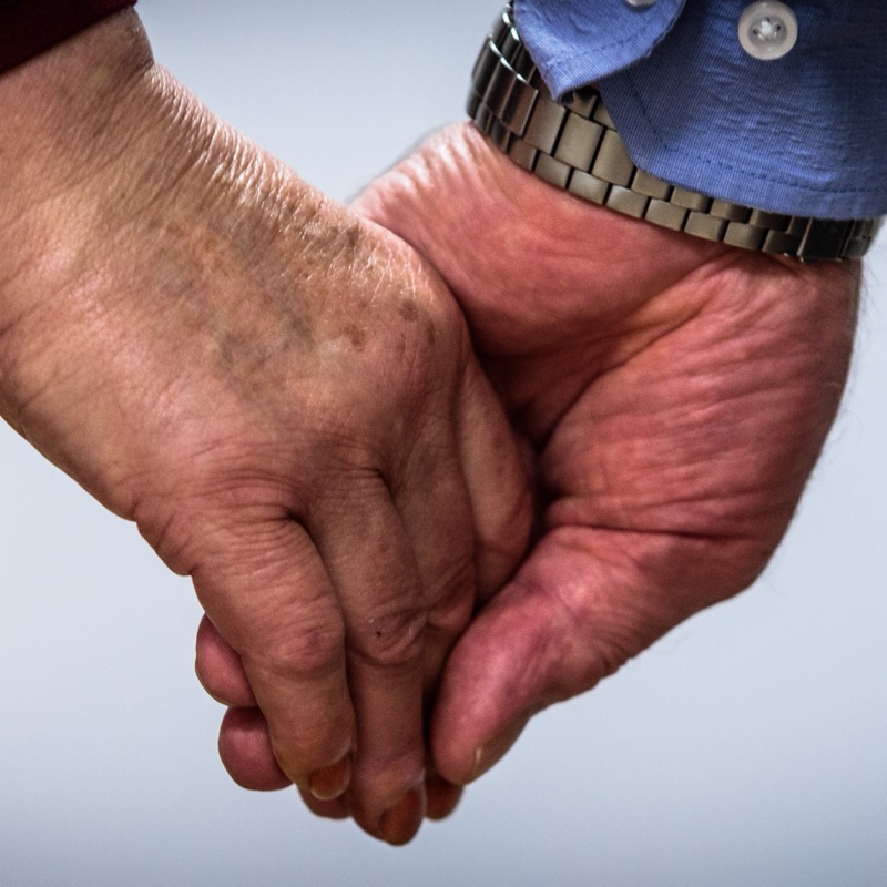 Eine ältere Hand wird von einer jüngeren Hand gehalten